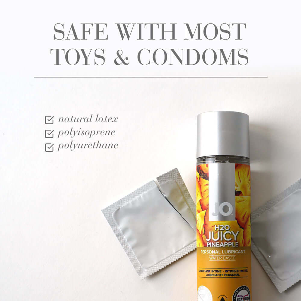 JO H2O Juicy Pineapple Lube bottle with condoms, showcasing pineapple flavored lubricant safety with toys and condoms.