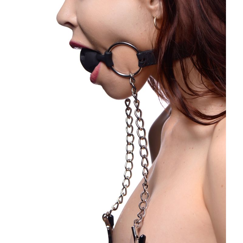 Hinder breathable silicone ball gag with nipple clamps being worn by a model, showcasing its design and functionality.