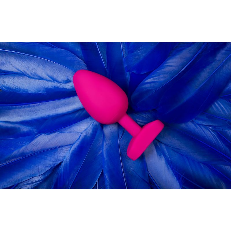 Gplug Large Bioskin Sweet Raspberry on blue feathers, a bioskin sex toy raspberry designed for pleasure.