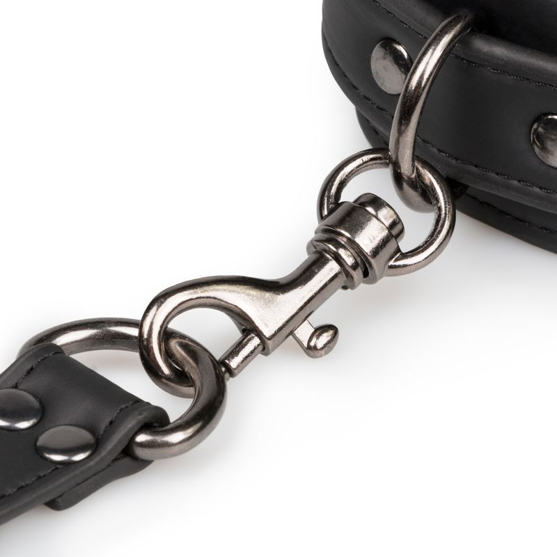 Close-up of a clip fastener on a Hogtie With Hand and Ankle Cuffs, showcasing its sturdy black leather and metal design.