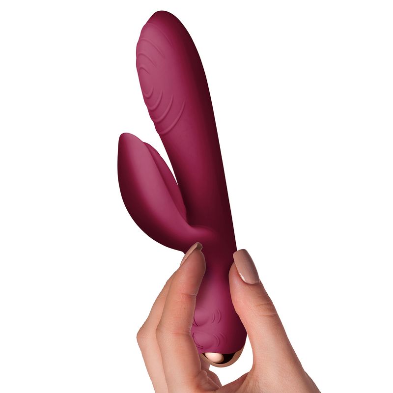 Every Girl Rabbit Vibrator Burgundy held in hand, showcasing its elegant design and dual motors for ultimate satisfaction.
