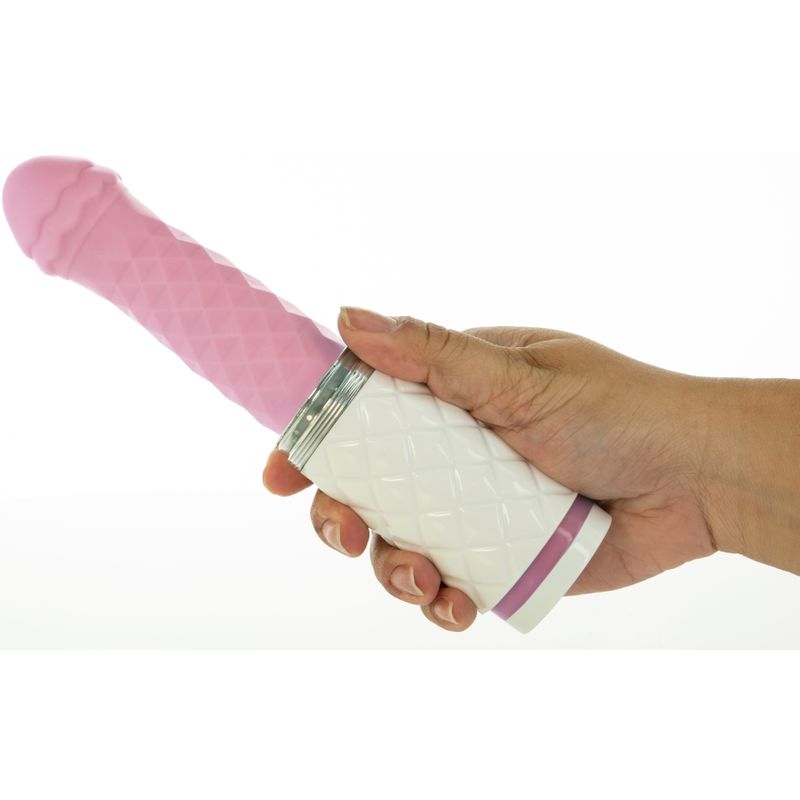 Person's hand holding the Feisty Pink thrusting vibrator with a diamond pattern for pleasure.