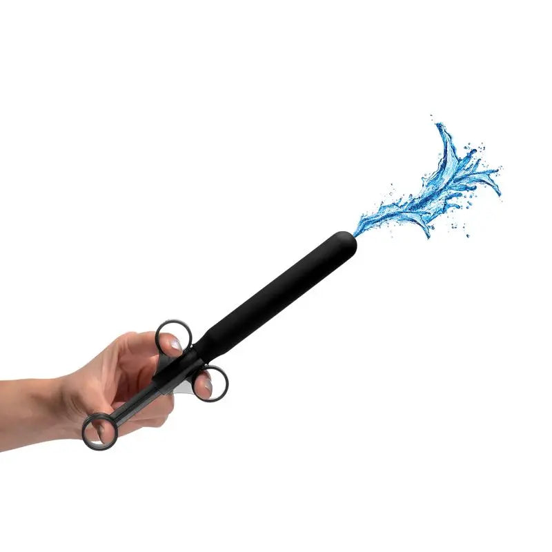 Smooth Silicone Lubricant Launcher in use, demonstrating easy application with finger loops and water effect.