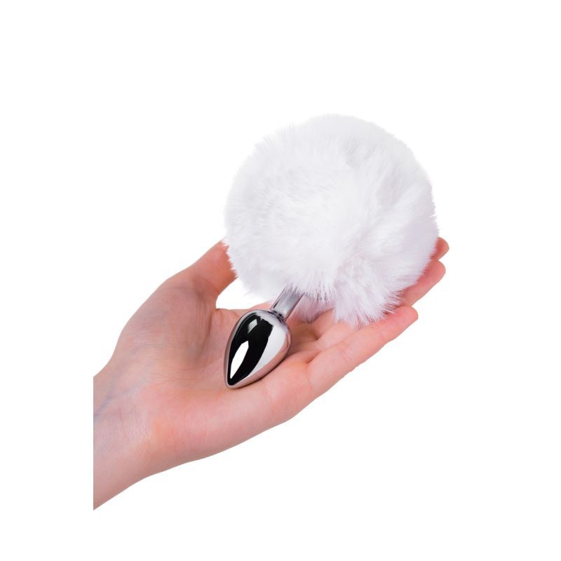 Small bunny tail anal plug held in hand, featuring a fluffy white faux fur tail and shiny silver metal base.
