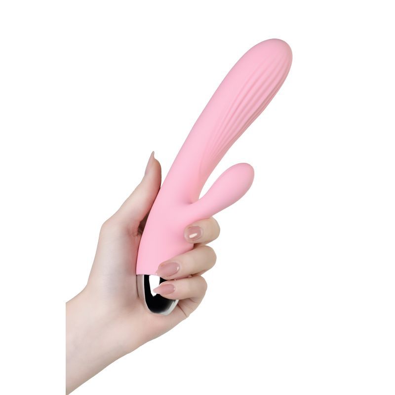 JOS Milly heating vibrator held in hand, featuring pale pink silicone design and ergonomic shape.