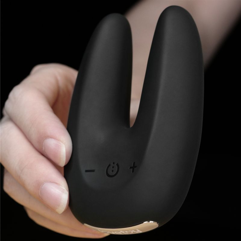 O Sensual Rapture Dual Motor Clit Massager Vibrator in a hand, showcasing its sleek black design and control buttons.