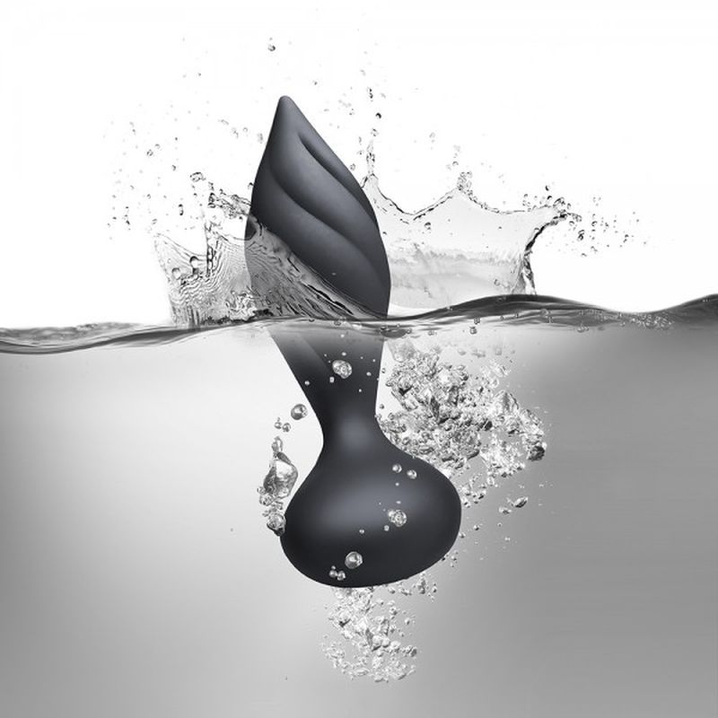 Petite vibrating butt plug submerged in water, creating splashes, showcasing its sleek design and contours.