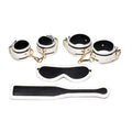 Kink In the Dark glowing bondage set featuring cuffs, paddle, and blindfold for adventurous play.