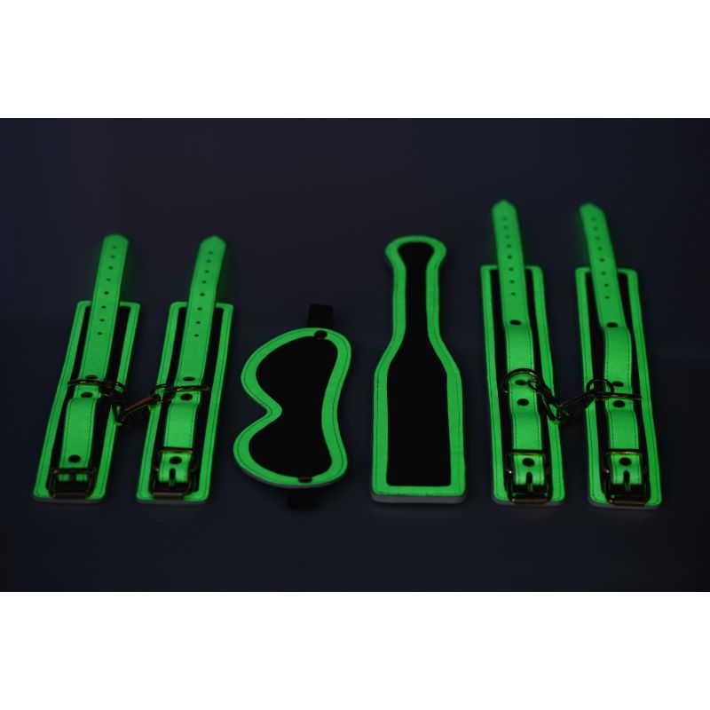 Glowing bondage set featuring wrist cuffs, ankle cuffs, paddle, and blindfold in fluro green for nighttime play.