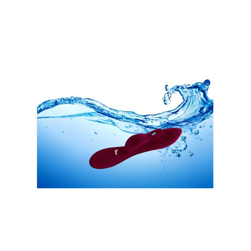 G spot thumping rabbit vibrator submerged in water, showcasing its waterproof design and stylish ruby color.