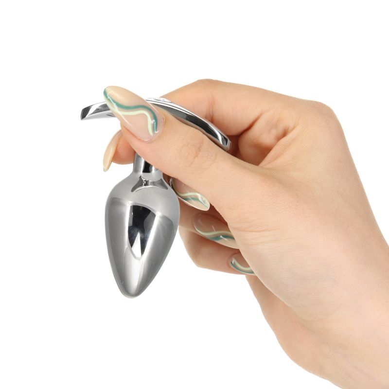 Hand holding a stainless steel anal plug with crystal, showcasing the sleek design and tapered tip for easy insertion.