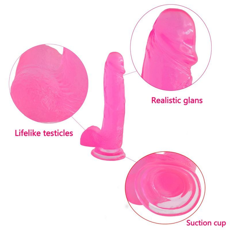 Close-up of large realistic crystal dildo with realistic glans, lifelike testicles, and suction cup base.
