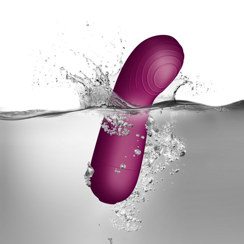 Pink silicone body massager by SugarBoo submerged in water, showcasing its vibrant color and sleek design.