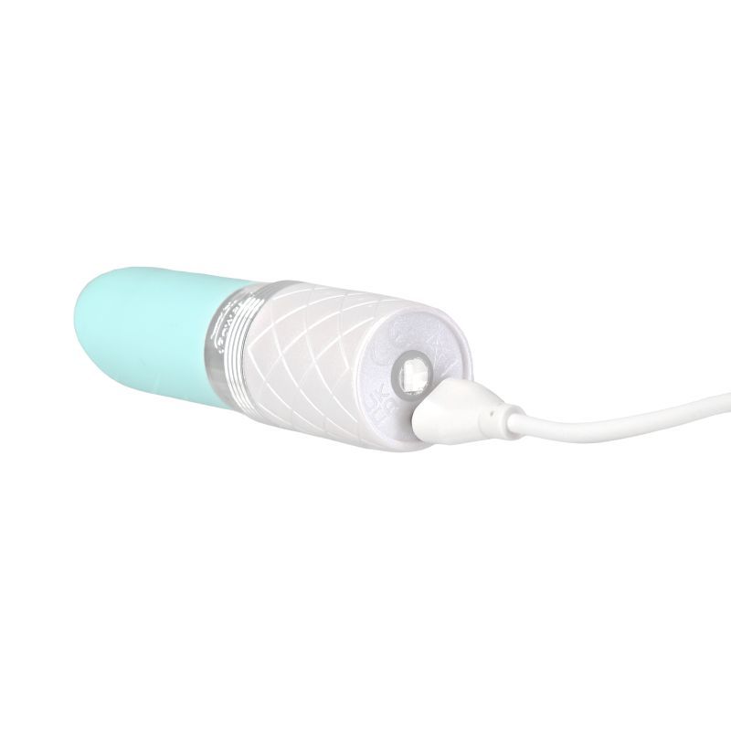 Pillow Talk Lusty lipstick clitoral vibrator in teal color, charging with USB cable.