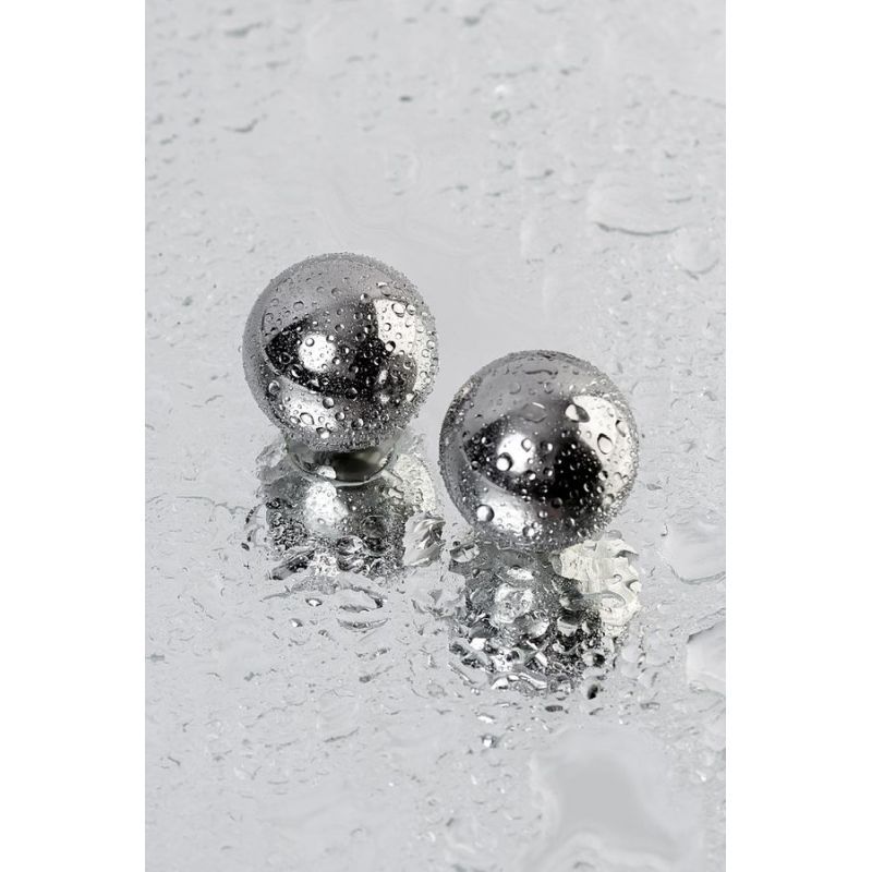 Silver metal 2 Pc vaginal balls 25mm with raindrops on a reflective surface.