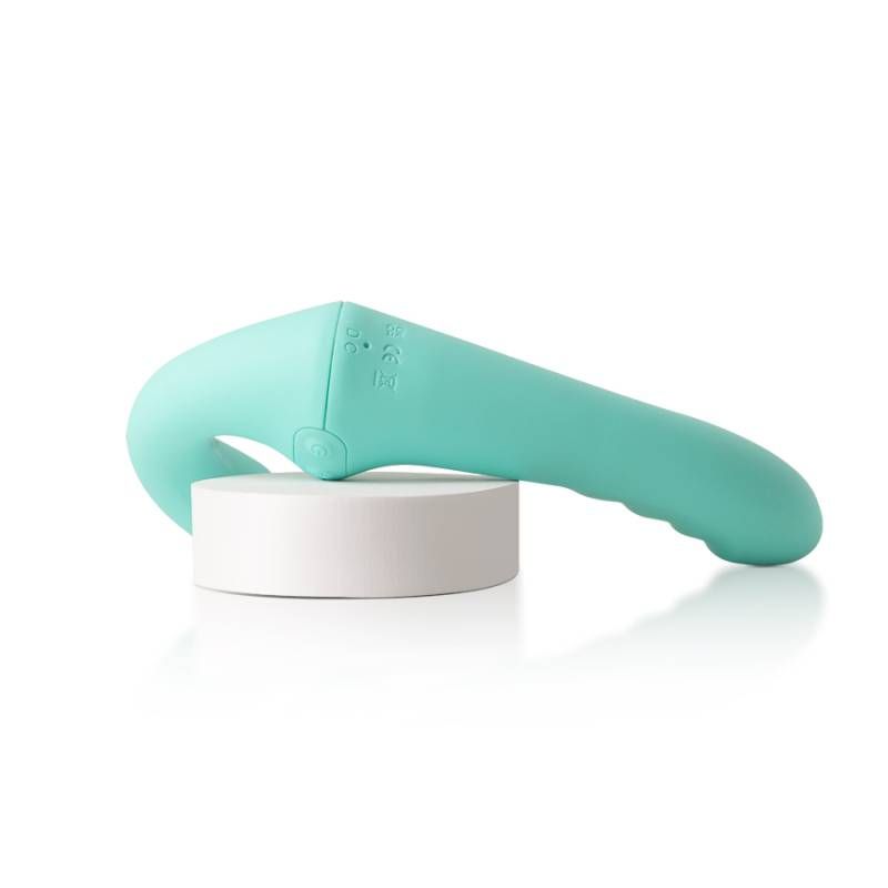 VibraTwin rechargeable strapless strap on vibrator with remote placed on a white base, showcasing its premium silicone design.