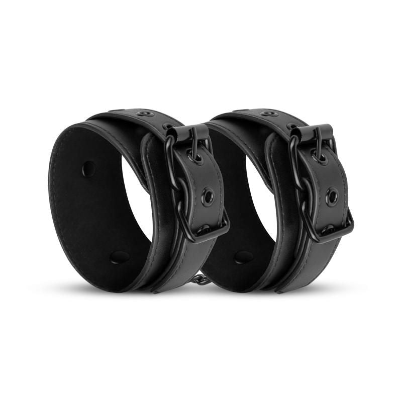 Adjustable faux leather handcuffs in black, made of durable synthetic leather with clip closures and a chain.