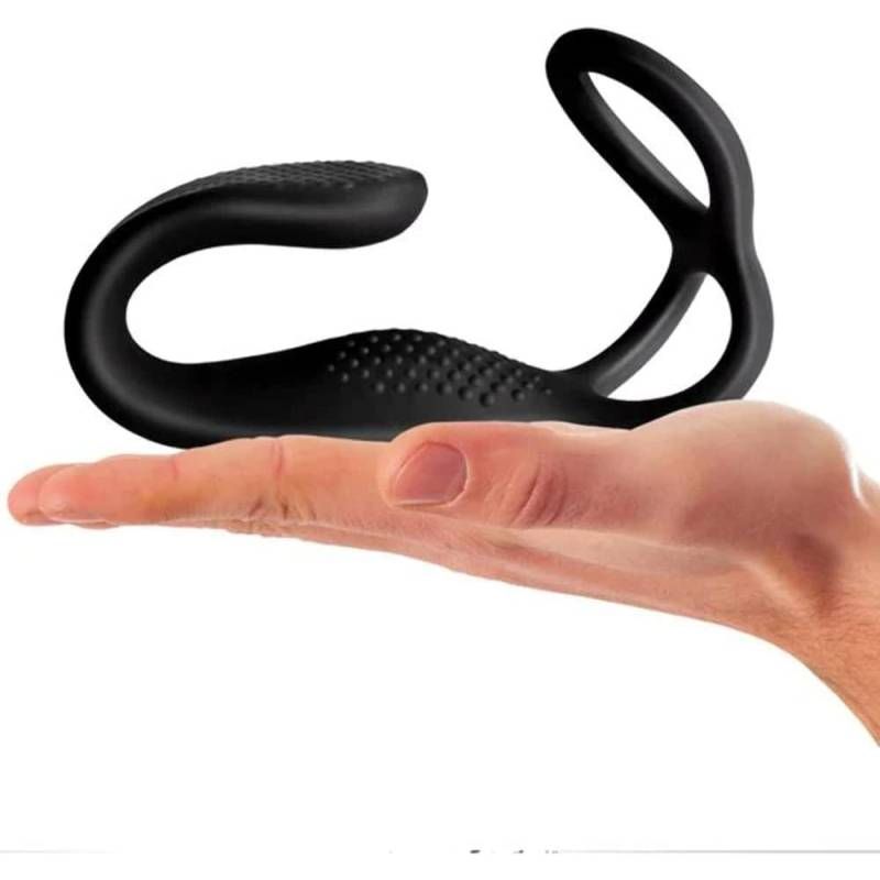 The Vibe anal cock and ball stimulator held in a hand, showcasing its sleek design and ergonomic shape.