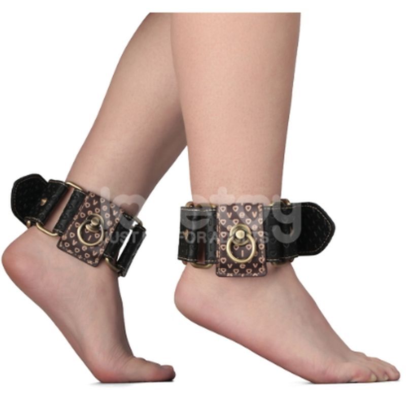 Faux leather ankle cuffs with adjustable straps and metallic hardware on bare feet.