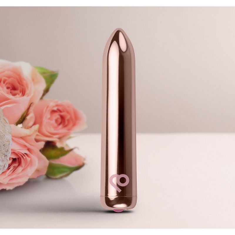 Golden Rose Rechargeable Bullet Vibrator next to pink roses, showcasing its elegant design and compact size.