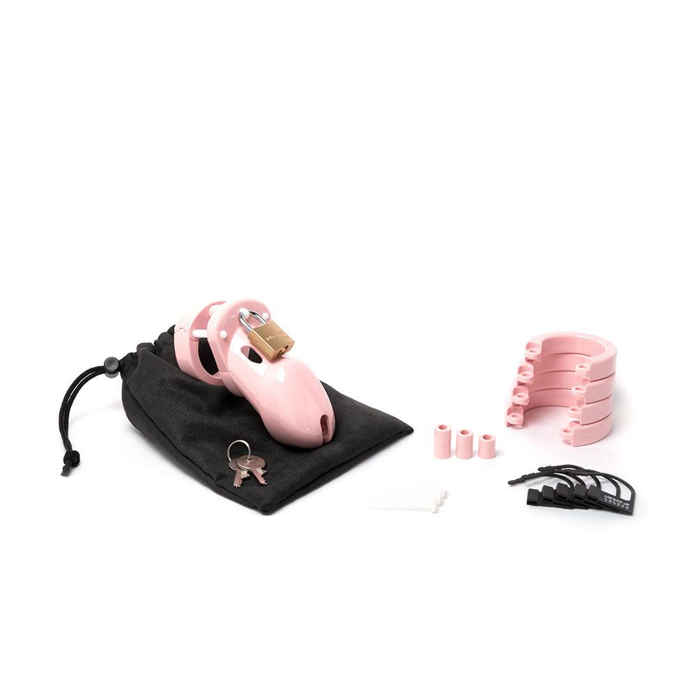 CB-3000 chastity cock cage kit with pink cage, locking mechanism, and accessories on black pouch.