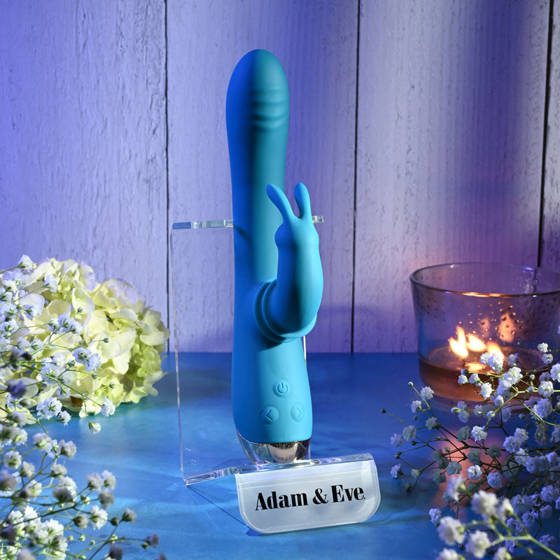 Adam & Eve SHIMMY & SHAKE VELVET RABBIT - 22.4 cm USB Rechargeable Rabbit Vibrator displayed with flowers and candle.