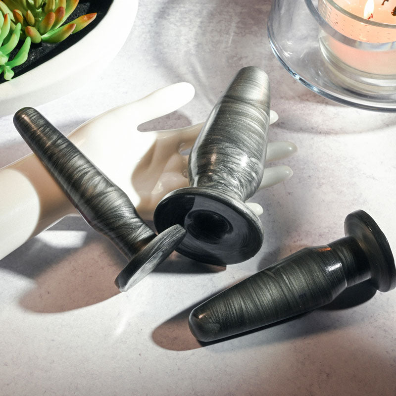 Adam & Eve ANAL ROCKETS TRAINER SET - Butt Plugs - Set of 3 Sizes displayed on a hand with succulent background.