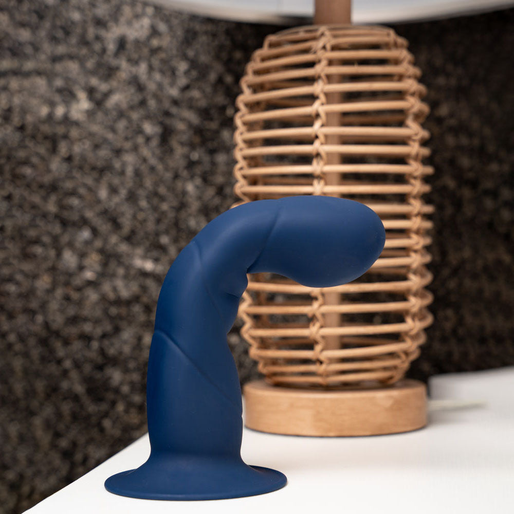 Maia MARIN -  - Dark  20.3 cm Dong on display next to a lamp showcasing its ergonomic design and flexibility.