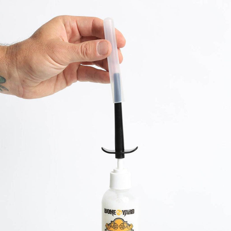 Boneyard Skwert Lube Injector -  Lube Injector for Bottles showing hand using the injector with lube bottle.