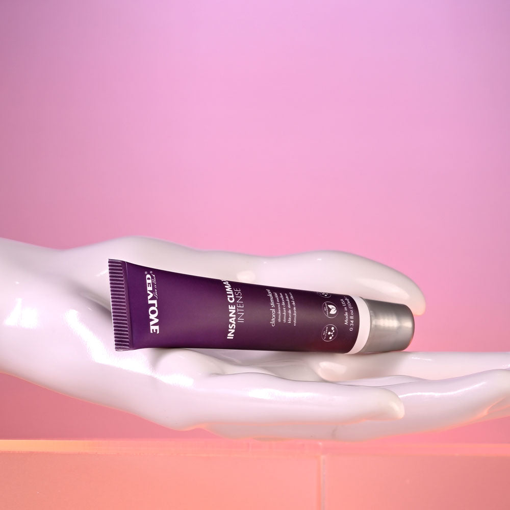 Evolved INSANE CLIMAX - INTENSE - Clitoral Stimulation Gel - 10 ml Tube displayed on a hand against a colorful backdrop.