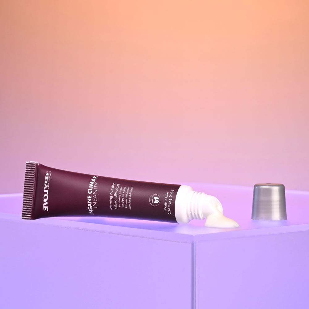 Evolved INSANE CLIMAX - INSANITY - Warming Buzzing Clitoral Stimulation Gel - 10 ml displayed on a purple surface.