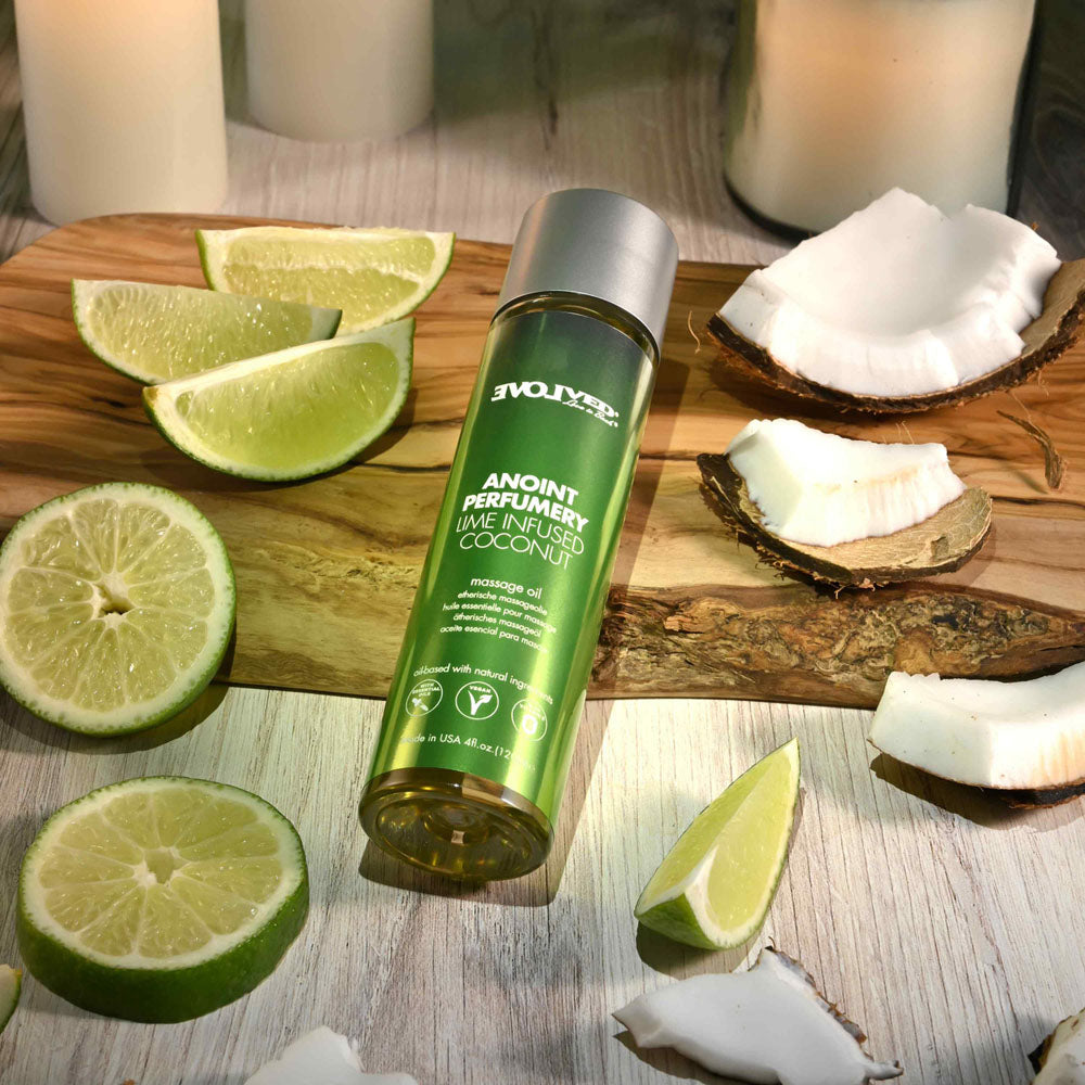 Evolved ANOINT PERFUMERY - Lime Infused Coconut - Lime Infused Coconut Massage Oil - 120 ml Bottle on wooden table with lime slices.