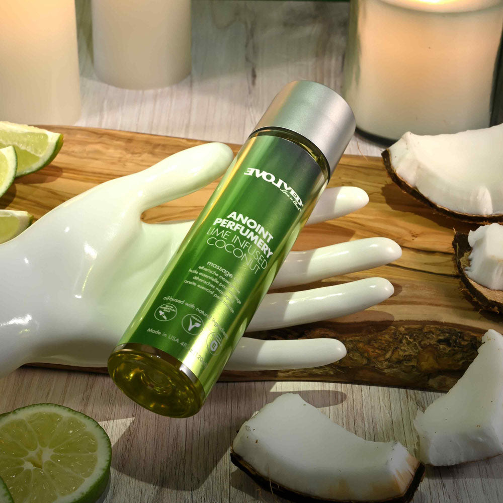 Evolved ANOINT PERFUMERY - Lime Infused Coconut - Lime Infused Coconut Massage Oil - 120 ml Bottle on a wooden surface with citrus and coconut.