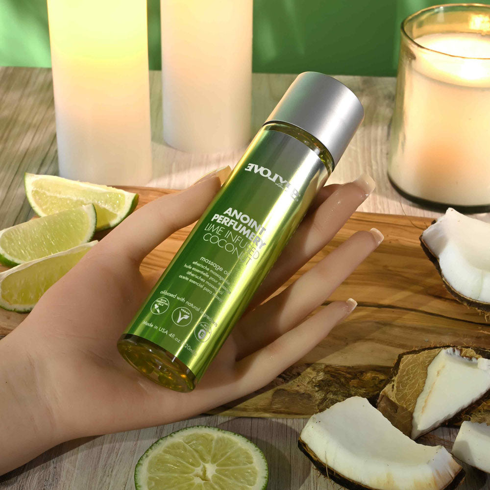 Evolved ANOINT PERFUMERY - Lime Infused Coconut - Lime Infused Coconut Massage Oil - 120 ml Bottle on a wooden table with lime and coconut.