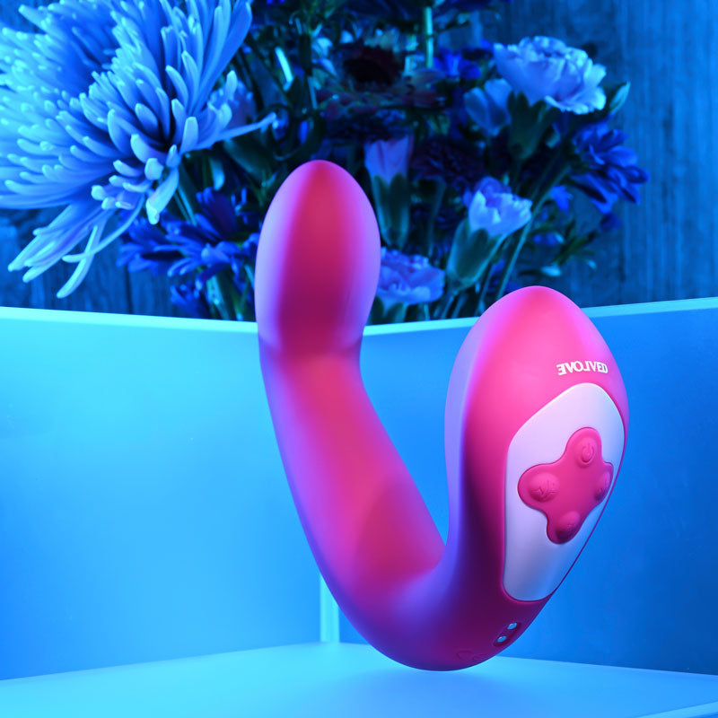 Evolved BUCK WILD -  USB Rechargeable Flicking Vibrator displayed among blue flowers, showcasing its vibrant design.