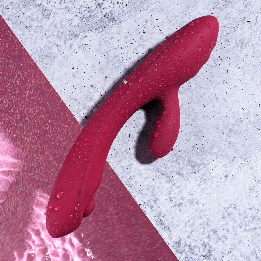 Evolved JAMMIN' G - Burgundy 20.1 cm USB Rechargeable Rabbit Vibrator with water droplets on a surface.