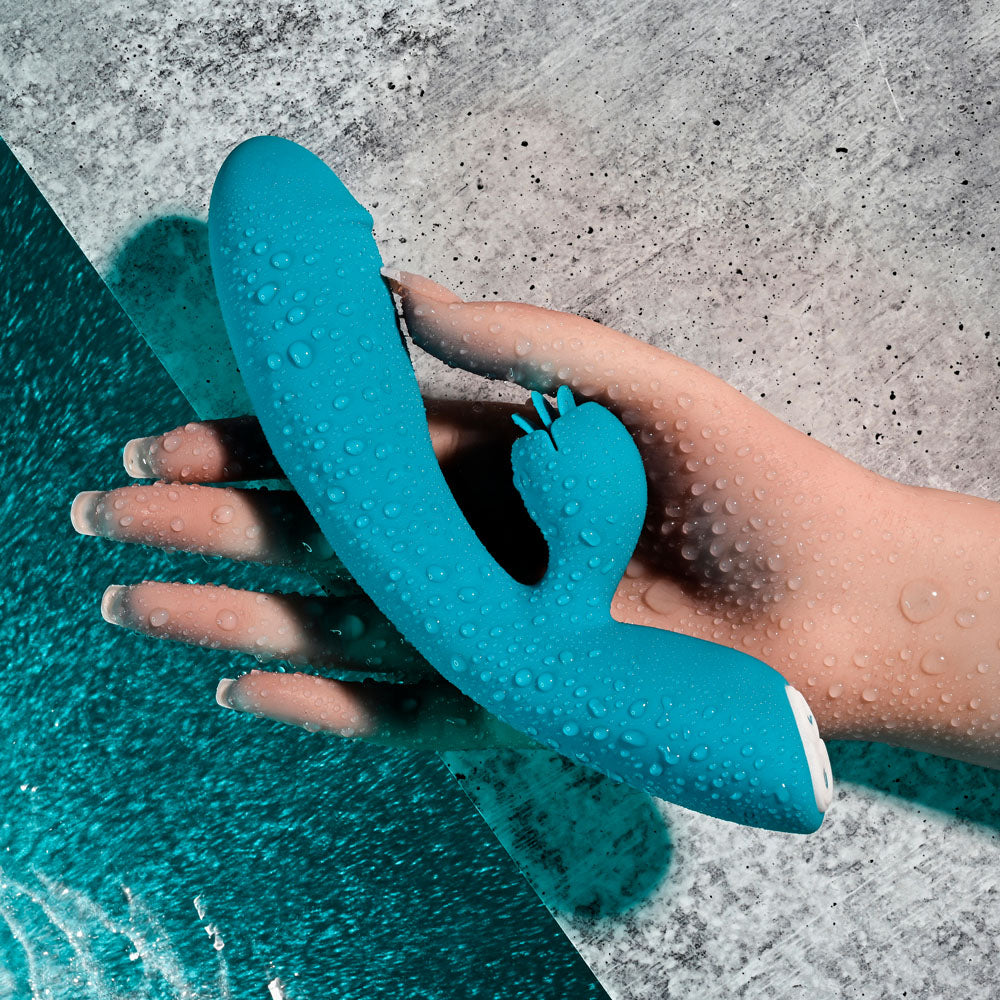 Evolved FIERCE FLICKER USB rechargeable rabbit vibrator resting in a hand, showcasing its waterproof design.