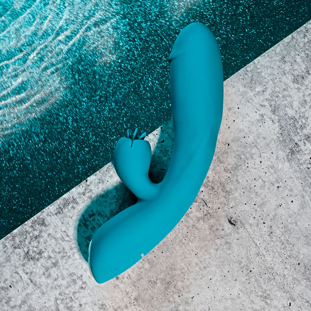 Evolved FIERCE FLICKER -  19.5 cm USB Rechargeable Rabbit Flicker Vibrator in teal color against a pool backdrop.