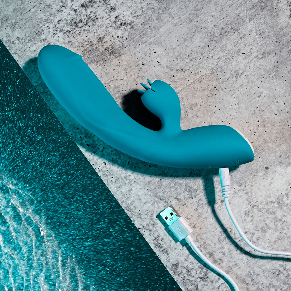 Evolved FIERCE FLICKER - 19.5 cm USB Rechargeable Rabbit Flicker Vibrator on a textured surface.