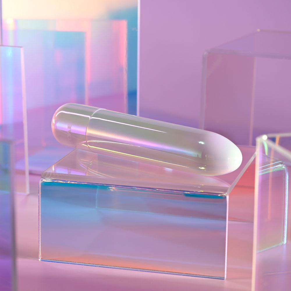 Evolved EASY DOES IT - Pearlescent 10 cm USB Rechargeable Bullet on a reflective surface, showcasing its iridescence.