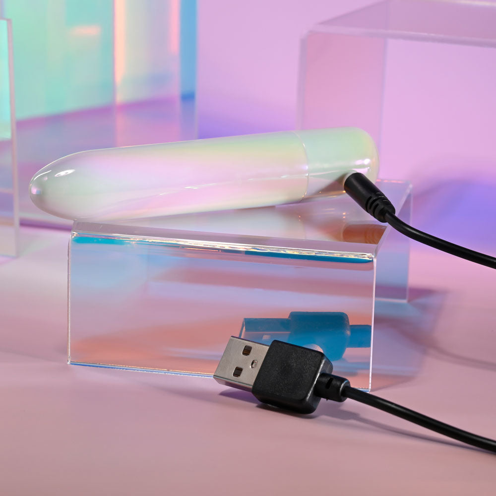 Evolved EASY DOES IT - Pearlescent 10 cm USB Rechargeable Bullet with charging cable on clear acrylic surface.