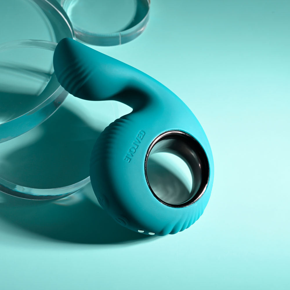 Evolved THUMBS UP - USB Rechargeable Stimulator in teal color on a teal background, showcasing its ergonomic design.