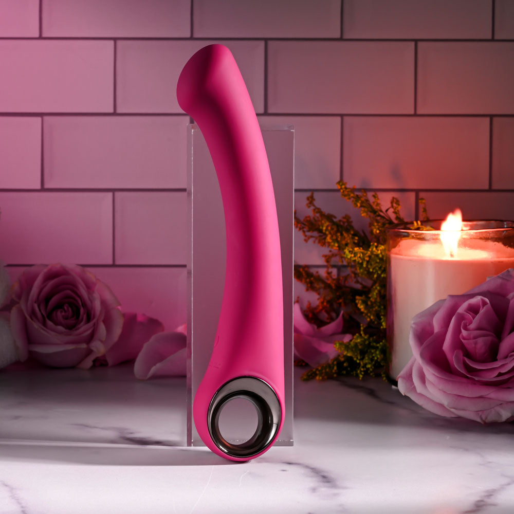 Evolved PLEASURE CURVE - 19 cm USB Rechargeable Vibrator displayed with roses and candles.