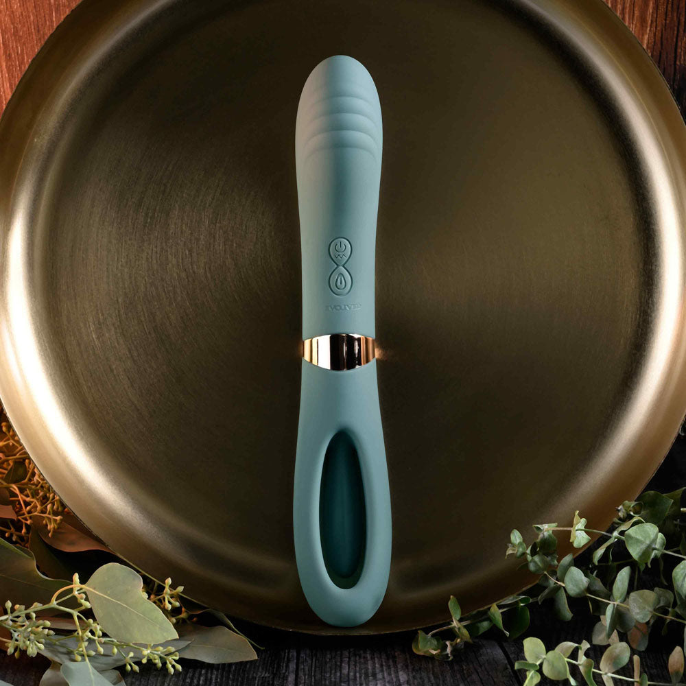 Evolved CHICK FLICK - Olive 24 cm USB rechargeable vibrator with flicking tip on a decorative plate.