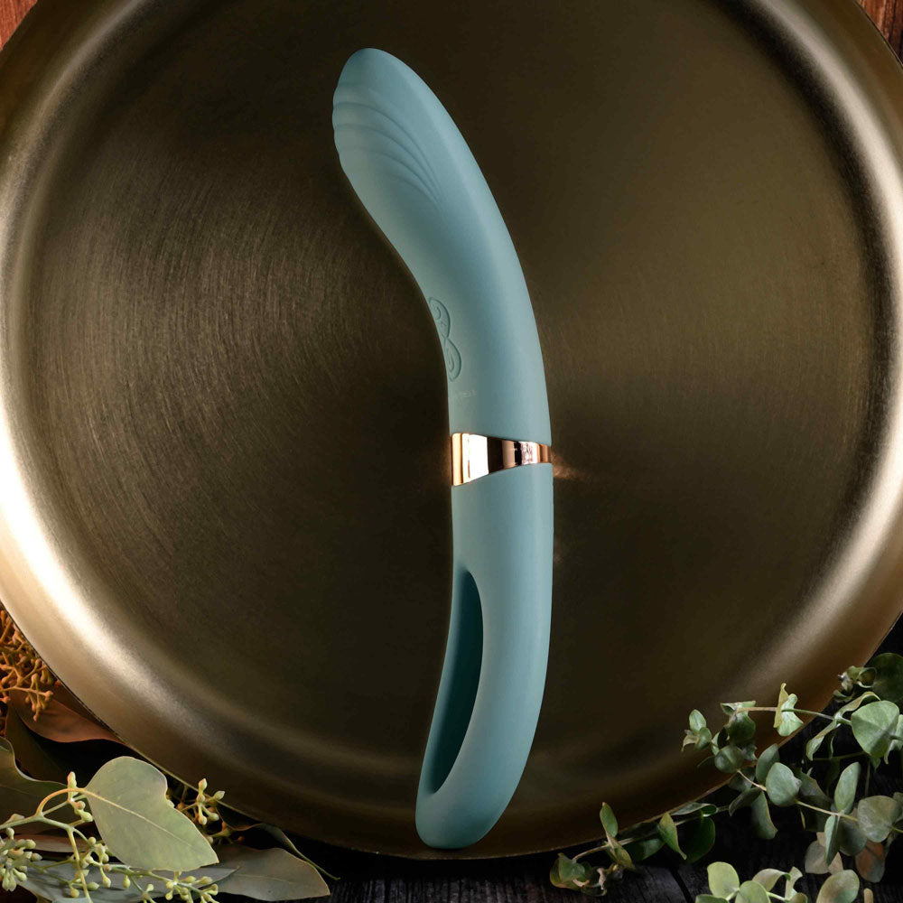 Evolved CHICK FLICK - Olive 24 cm USB rechargeable vibrator with flicking tip on a decorative surface.