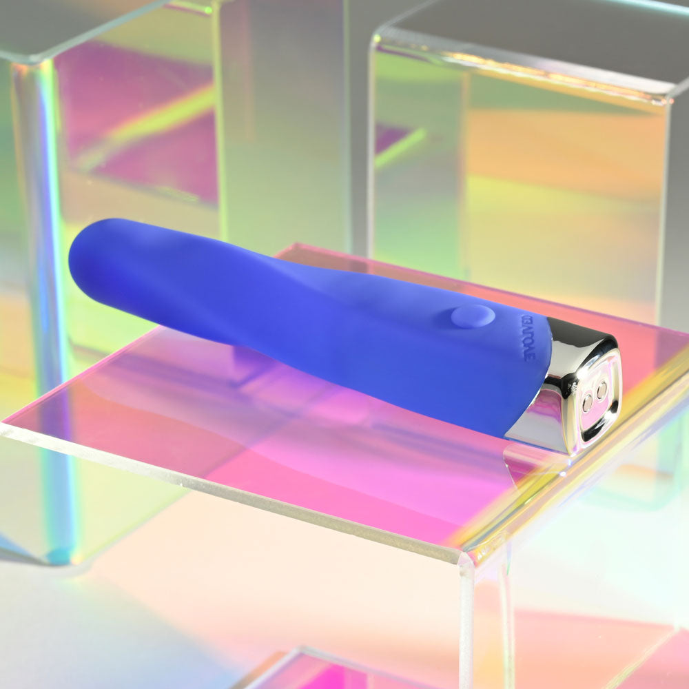 Evolved TWISTED TEMPTATION - 12 cm USB Rechargeable Bullet in blue resting on a colorful acrylic surface.