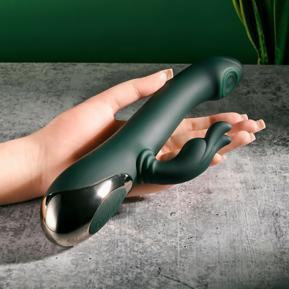 Evolved RABBIT TAP TAP - 25 cm USB Rechargeable Rabbit Vibrator with Tapping Tip in a hand against a green background.