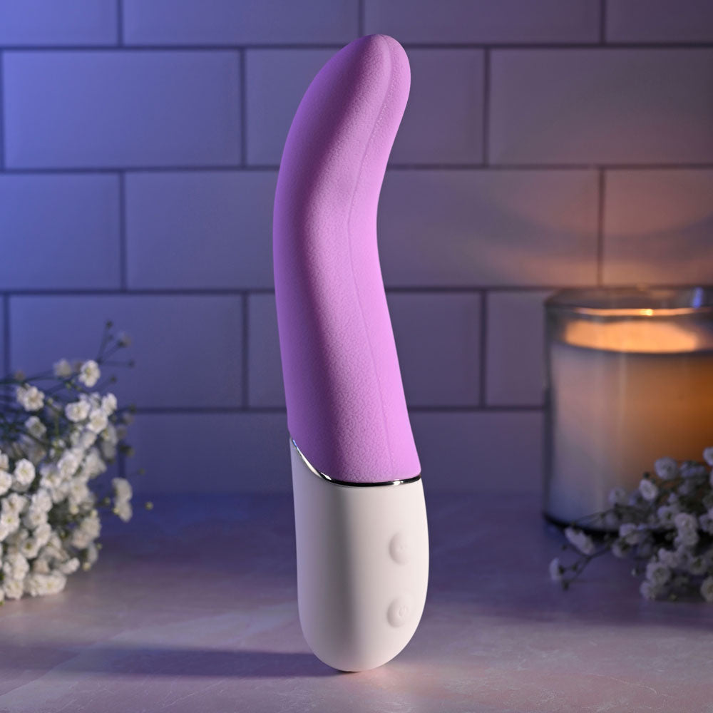 Evolved SLIP OF THE TONGUE - 21.1 cm USB rechargeable flicking tongue vibrator on a soft surface with flowers.