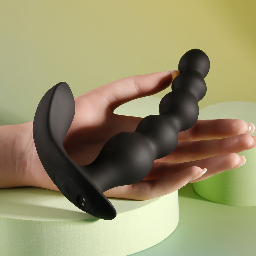 Evolved BEAD ME UP -  16.8 cm USB Rechargeable Vibrating Anal Beads with Wireless Remote held in a hand.