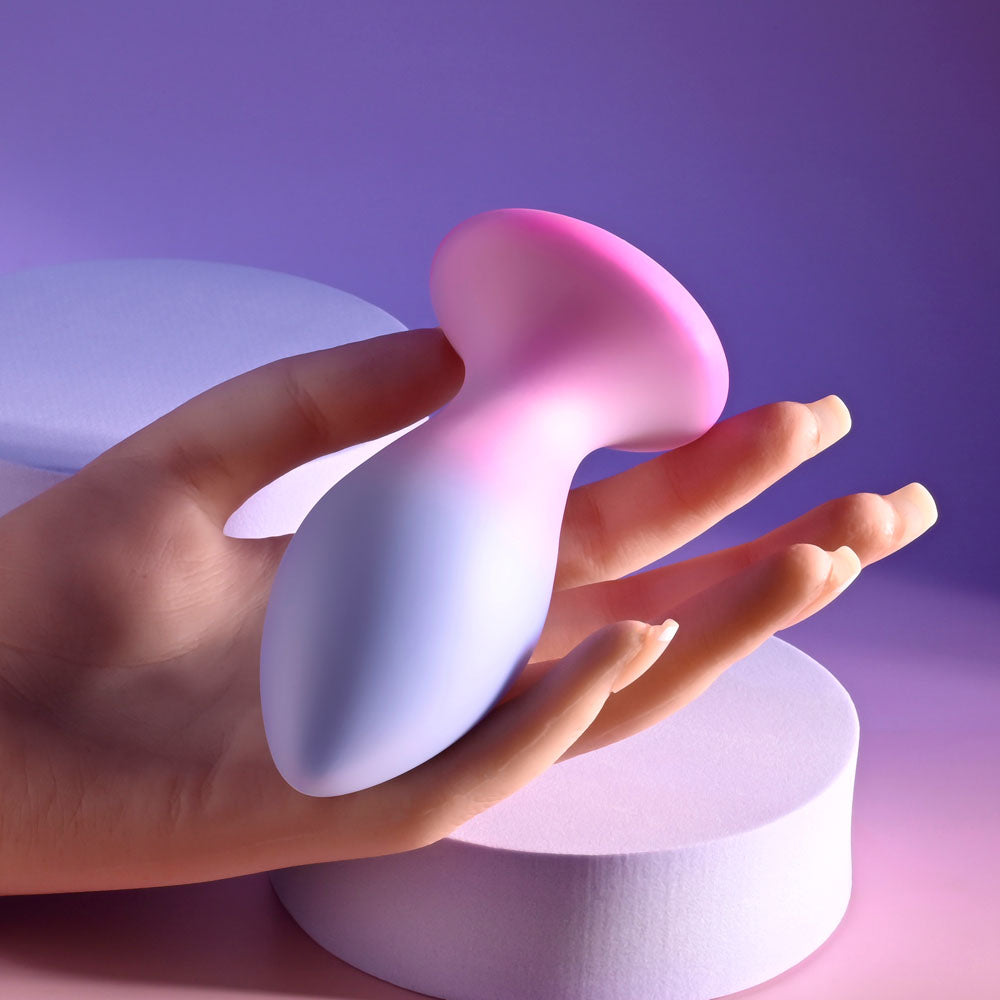 Evolved PARADISE PLUG - Pink/Purple 10.5 cm USB Rechargeable Vibrating Butt Plug with Wireless Remote held in hand.
